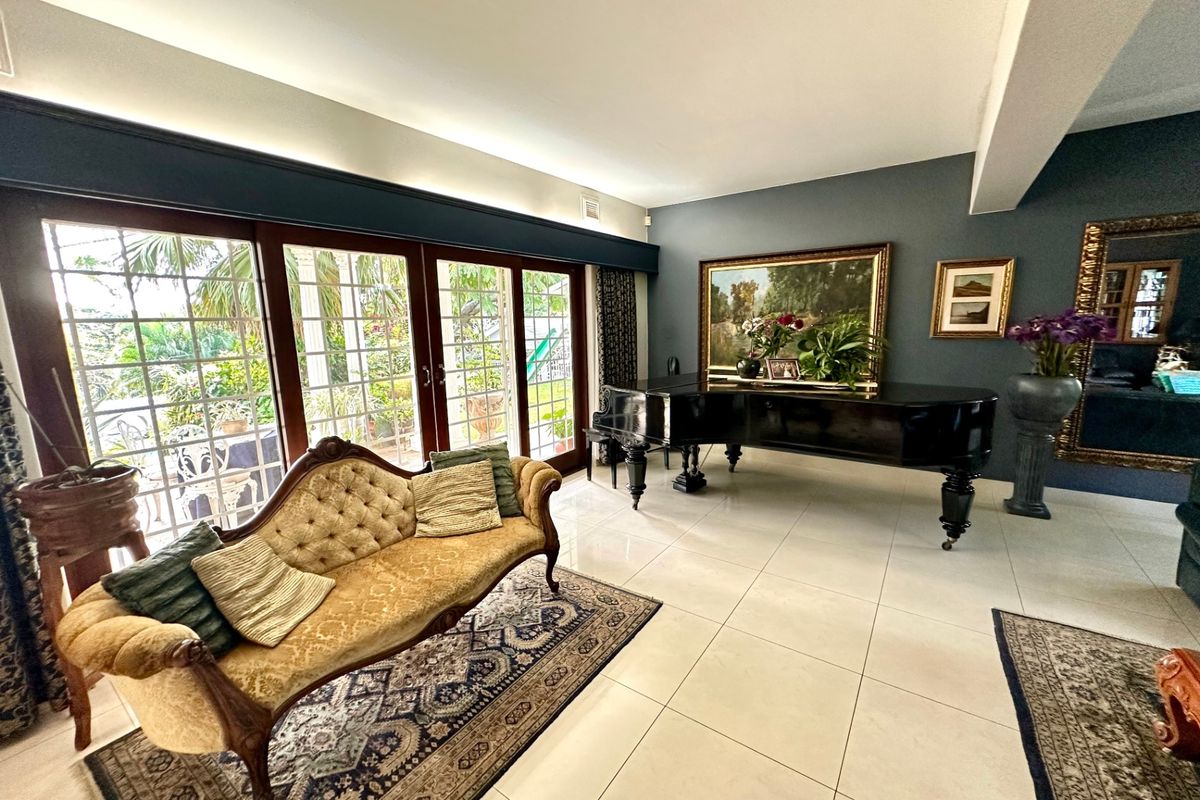 Spacious living room featuring large format floor tiles, recessed lighting, and expansive sliding glass doors providing direct access to the outdoor area.