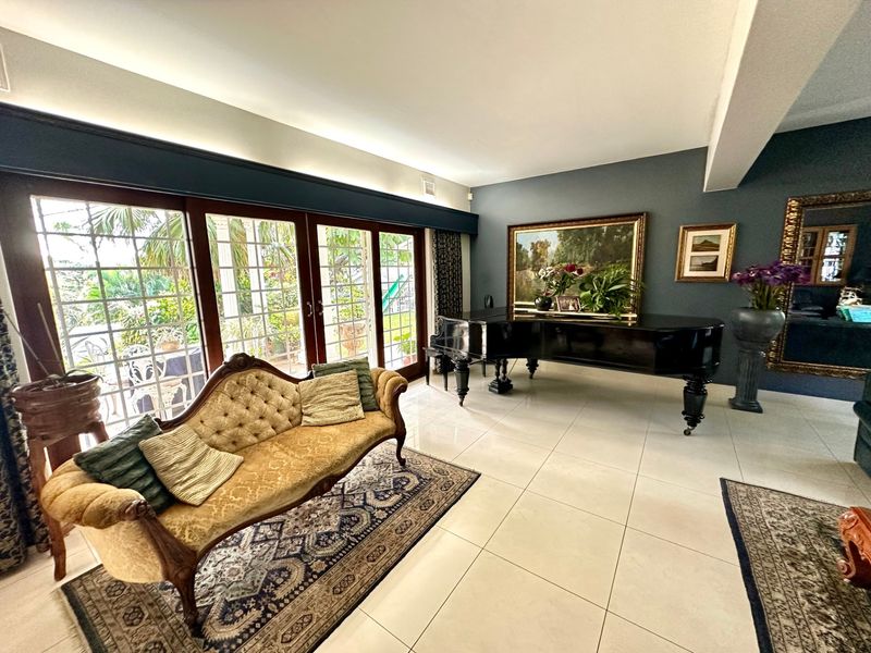 Spacious living room featuring large format floor tiles, recessed lighting, and expansive sliding glass doors providing direct access to the outdoor area.