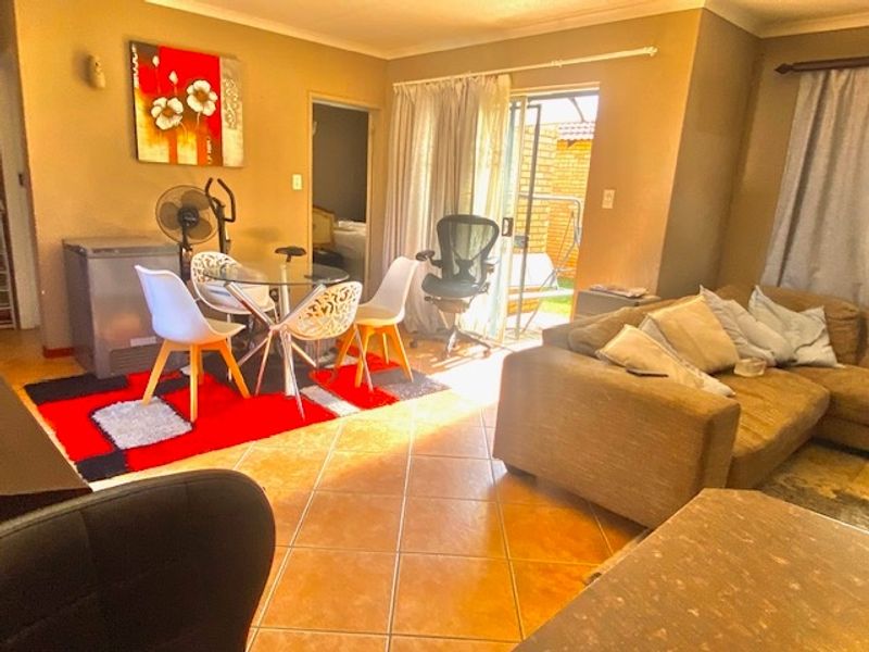 Open plan living and dining area featuring tiled flooring and a sliding glass door providing access to the outdoor space.