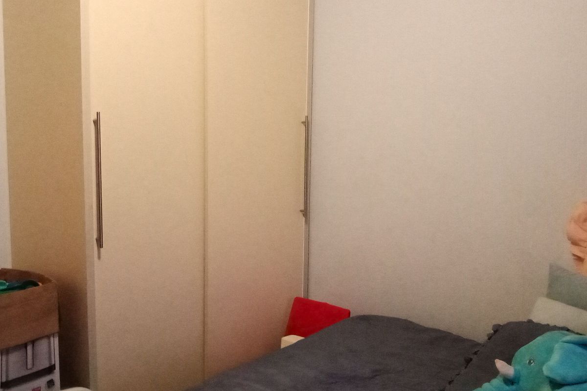 A bedroom featuring a built-in wardrobe with modern handles.