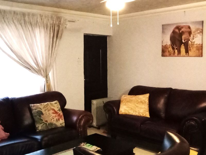 A living room featuring a ceiling fan and decorative cove cornicing, providing a functional space for relaxation.