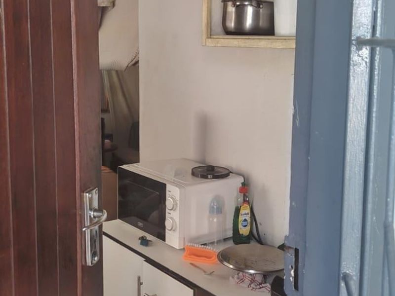 A compact scullery or utility area featuring built-in cabinetry and shelving, showing signs of ceiling water damage.