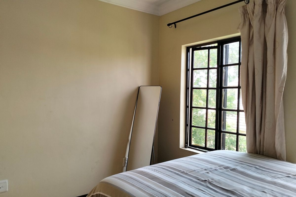 A bedroom featuring a window with a curtain rod, finished with cornice and skirting boards.