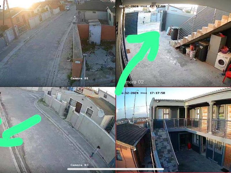 A multi-view security camera capture showing the exterior rear courtyard, paved areas, and a two-story residential structure with an external staircase and balcony.