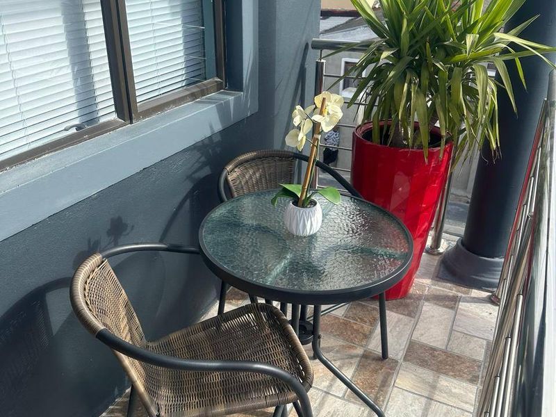 A compact balcony featuring tiled flooring and a modern stainless steel balustrade, providing a functional outdoor space.