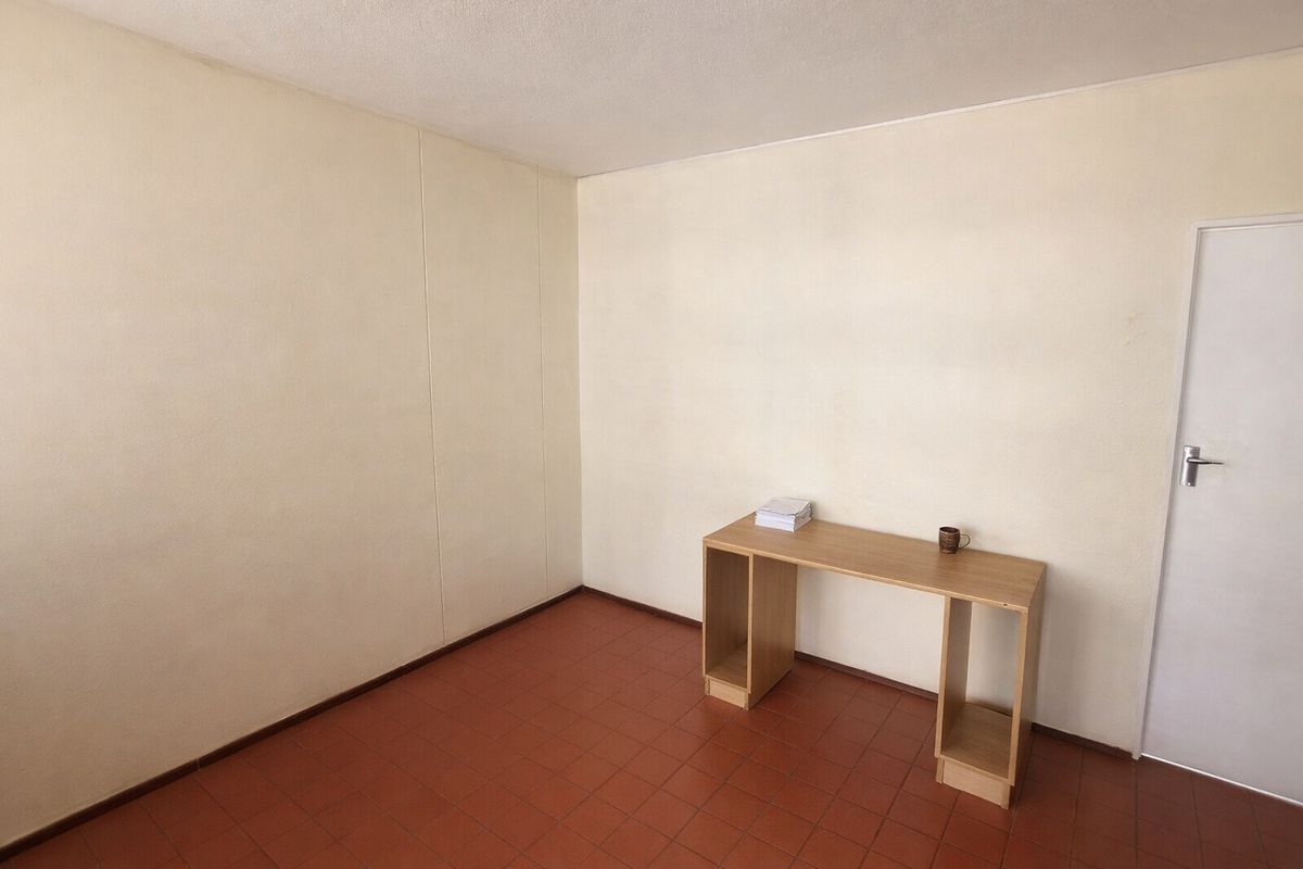 A vacant bedroom featuring tiled flooring and neutral wall finishes, offering a blank canvas for personalization or renovation.