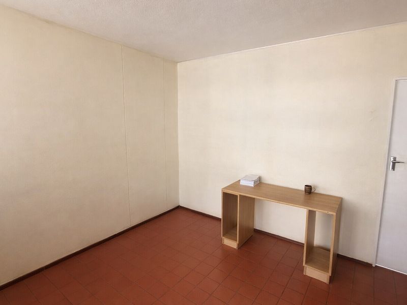 A vacant bedroom featuring tiled flooring and neutral wall finishes, offering a blank canvas for personalization or renovation.
