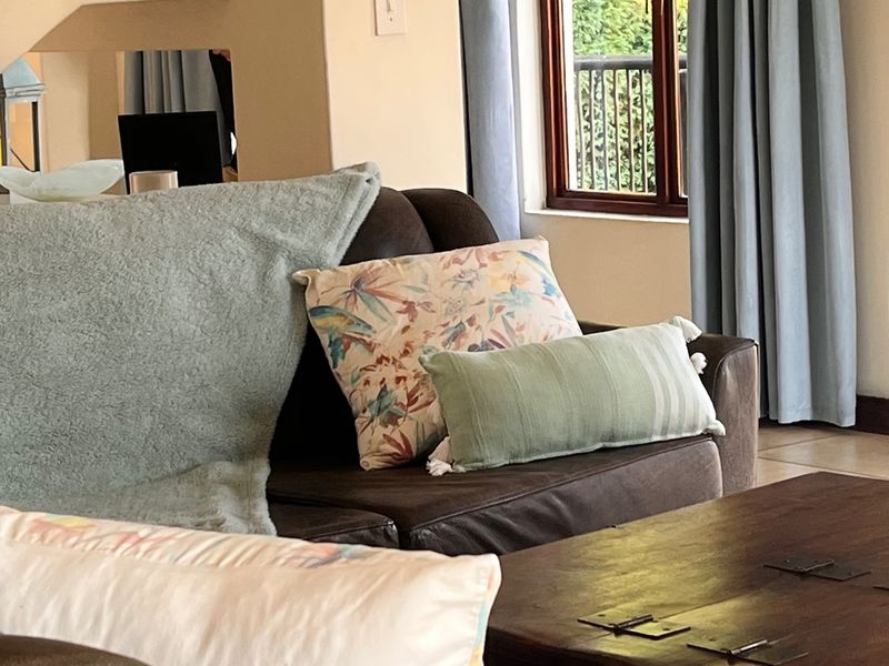A living room area featuring a freestanding fireplace, tiled flooring, and a window with curtains.