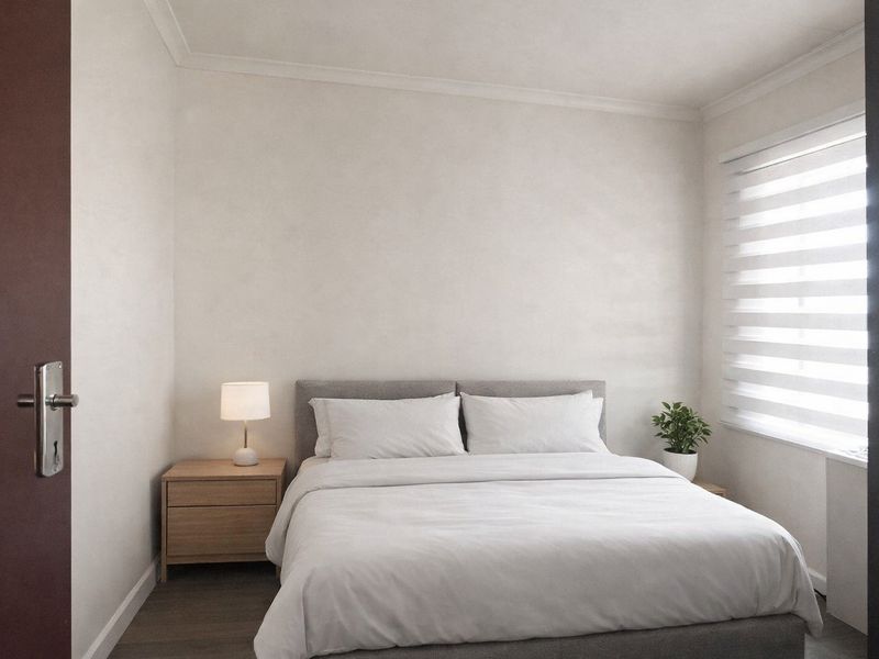 A well-maintained bedroom featuring neutral walls, coving, and modern roller blinds, providing a clean and comfortable living space.