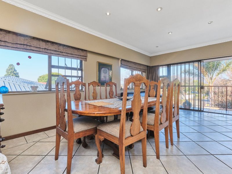 Spacious dining area featuring ceramic floor tiles, recessed downlighting, and large sliding glass doors providing access to an outdoor balcony.