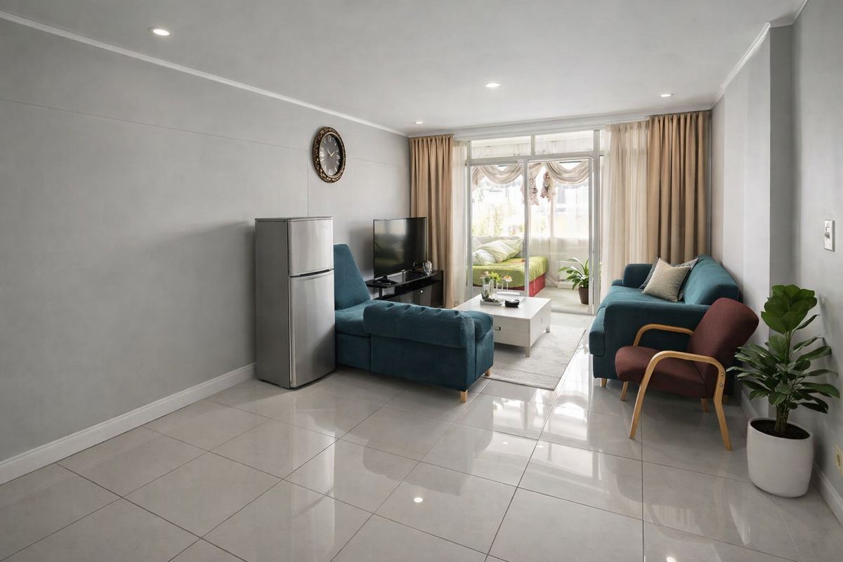 A bright living room featuring large format floor tiles, recessed lighting, and a sliding glass door providing access to an adjoining balcony.
