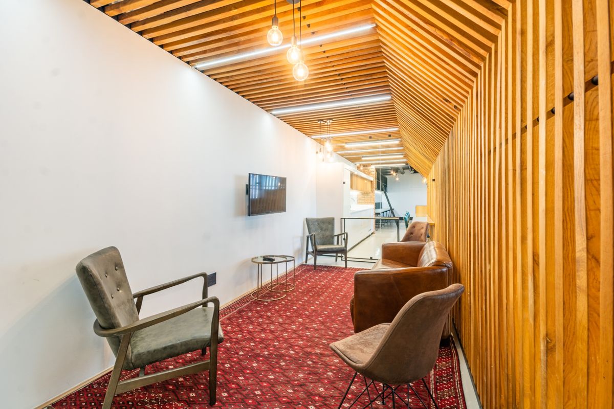 Modern commercial lounge area featuring distinctive timber slat ceiling and wall cladding, creating a warm and professional atmosphere.