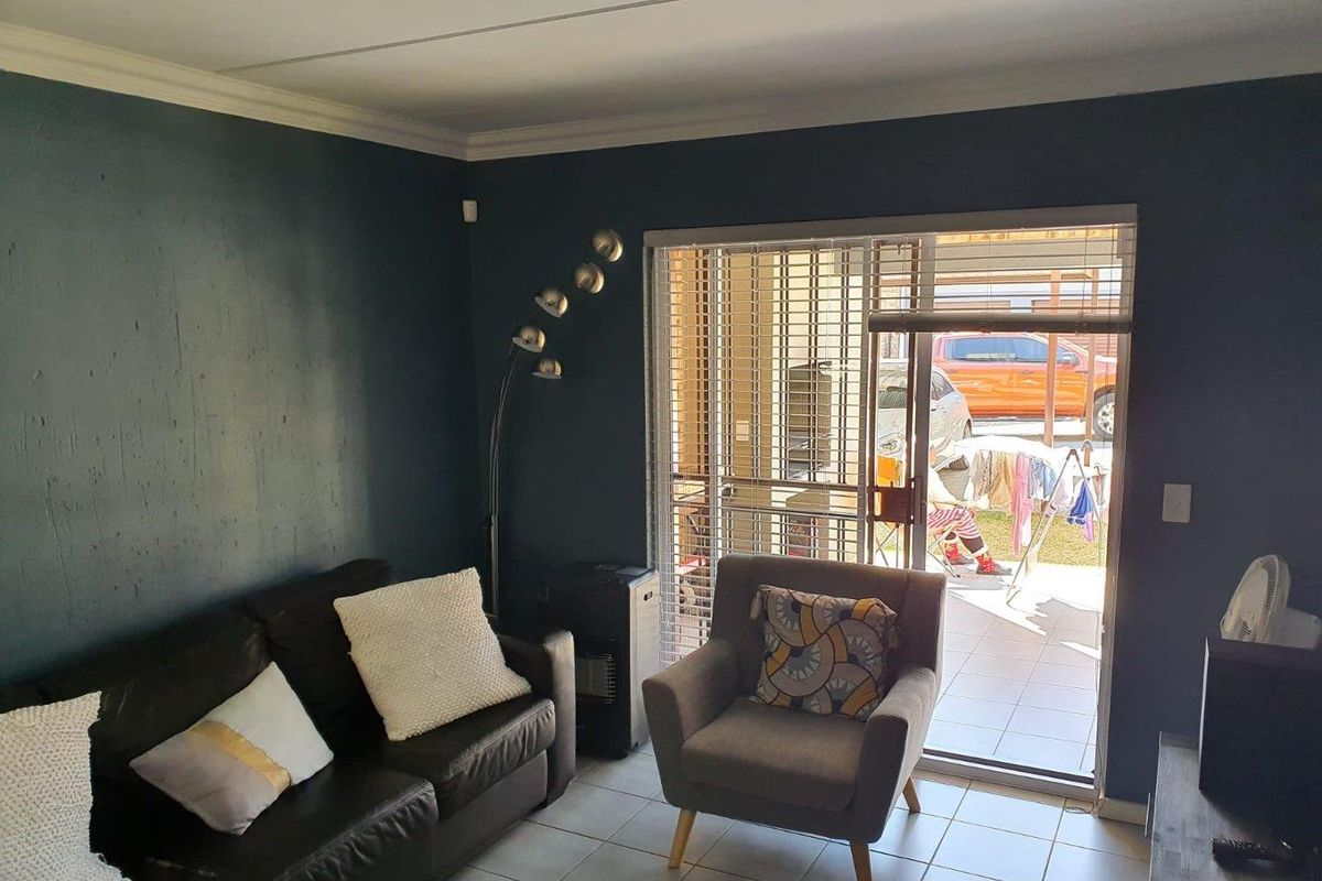 Living room featuring tiled flooring and a sliding glass door providing access to the exterior patio area.