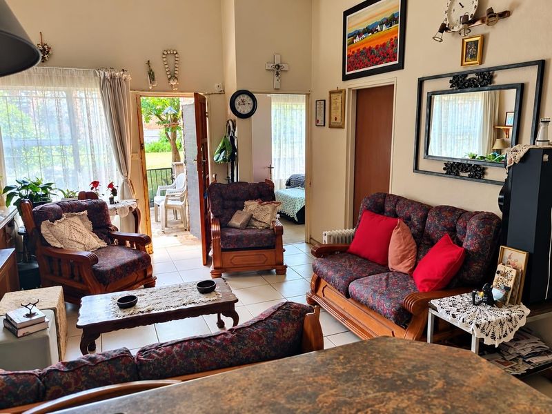 A spacious living room featuring tiled flooring and direct access to an outdoor patio area through a sliding glass door.