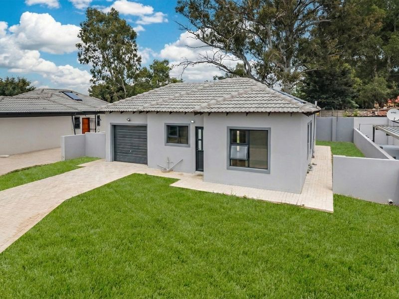 A well-maintained single-story residential property featuring a tiled roof, paved driveway, and a secure boundary wall with a private garden.