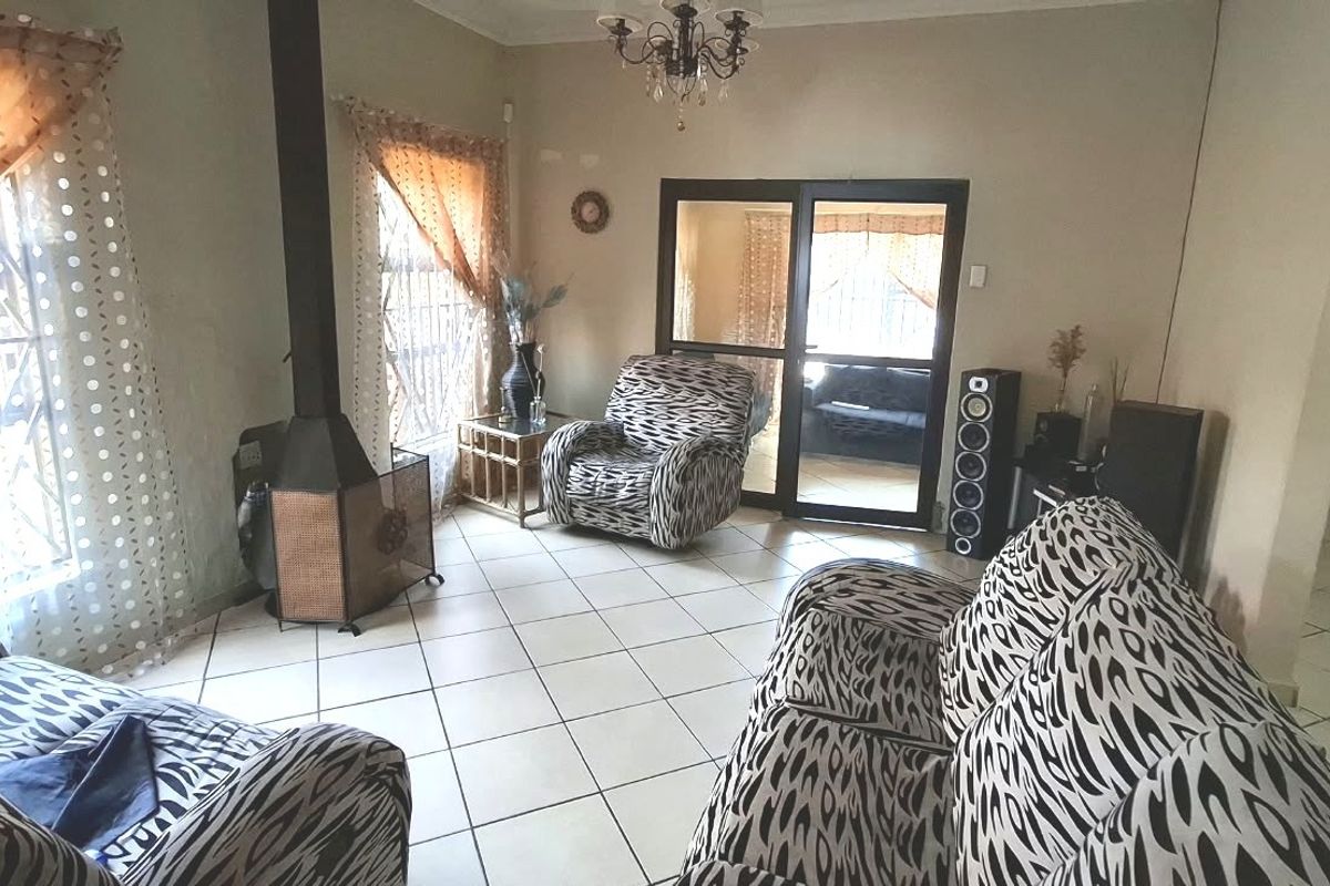 A living room featuring tiled flooring, a freestanding fireplace, and a sliding glass door leading to an adjacent space.