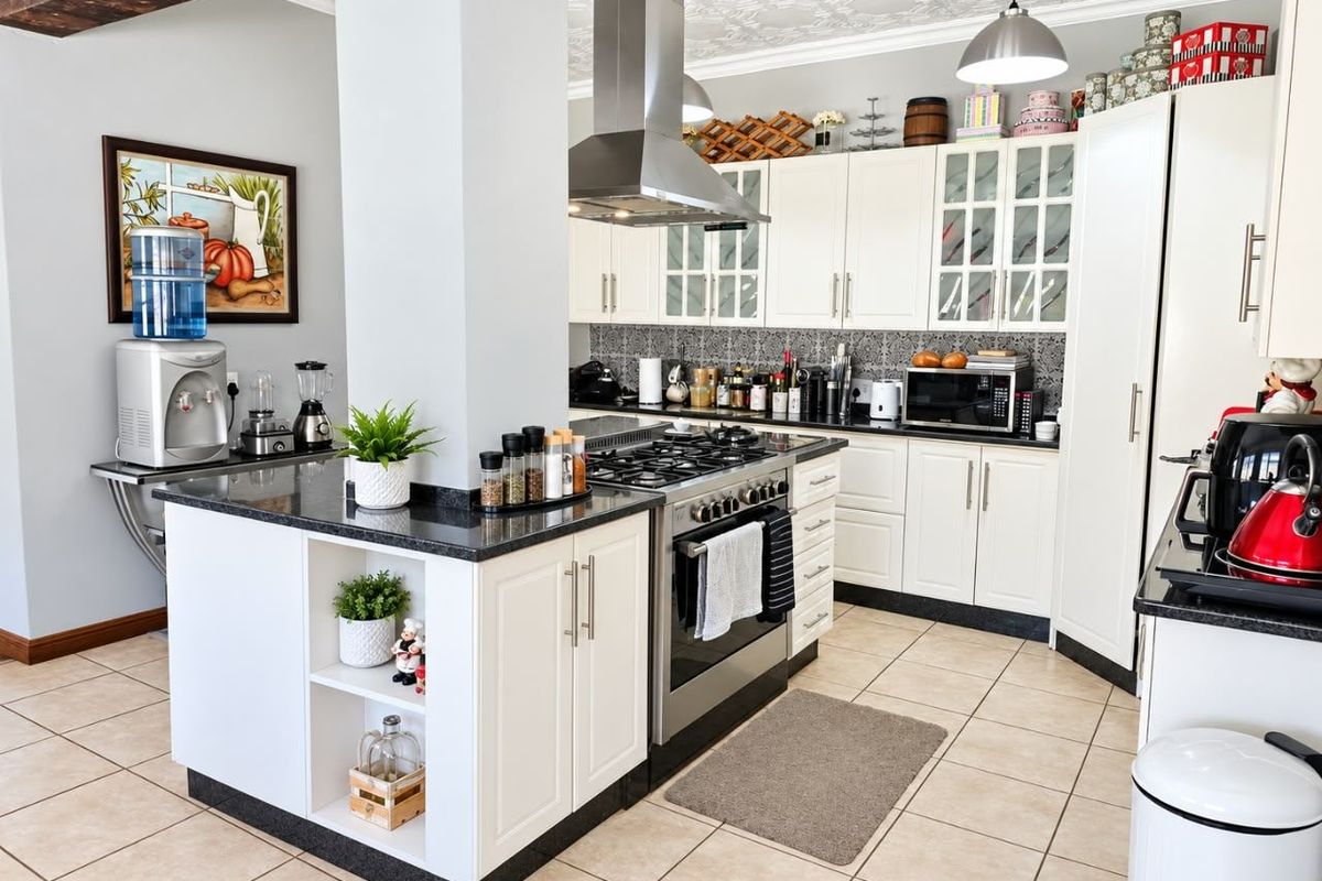 A well-maintained kitchen featuring white shaker cabinetry, granite countertops, a gas cooktop with stainless steel extractor, and decorative tiled backsplash.