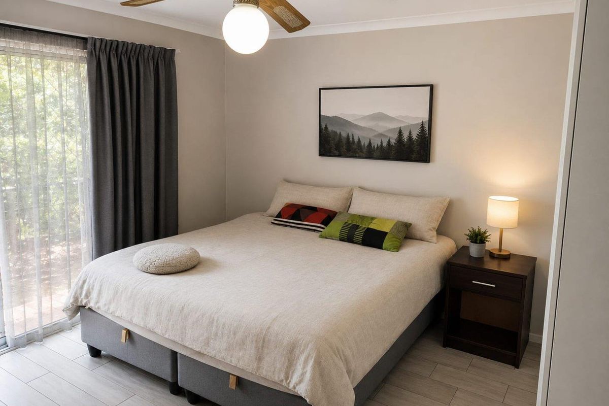 A well-maintained bedroom featuring tiled flooring, a ceiling fan, and sliding glass doors providing access to the exterior.