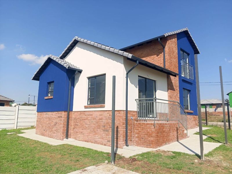 A modern double-storey house exterior featuring a combination of face brick and painted plaster finishes with a tiled roof and metal balcony railings.