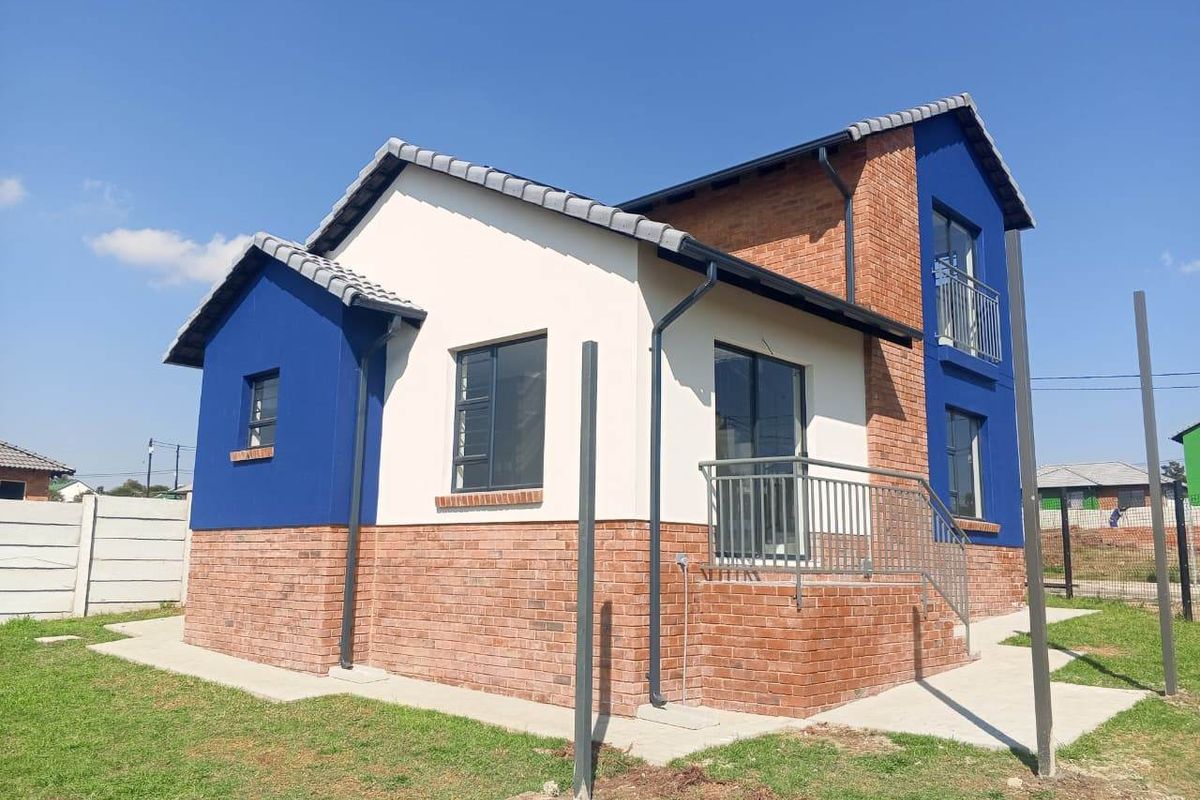 A modern double-storey house exterior featuring a combination of face brick and painted plaster finishes with a tiled roof and metal balcony railings.