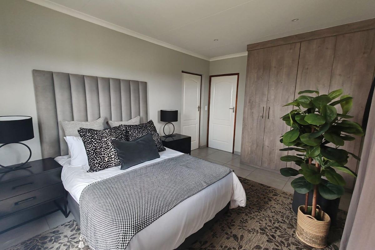 A well-maintained bedroom featuring neutral walls, tiled flooring, recessed lighting, and ample built-in cupboard storage.