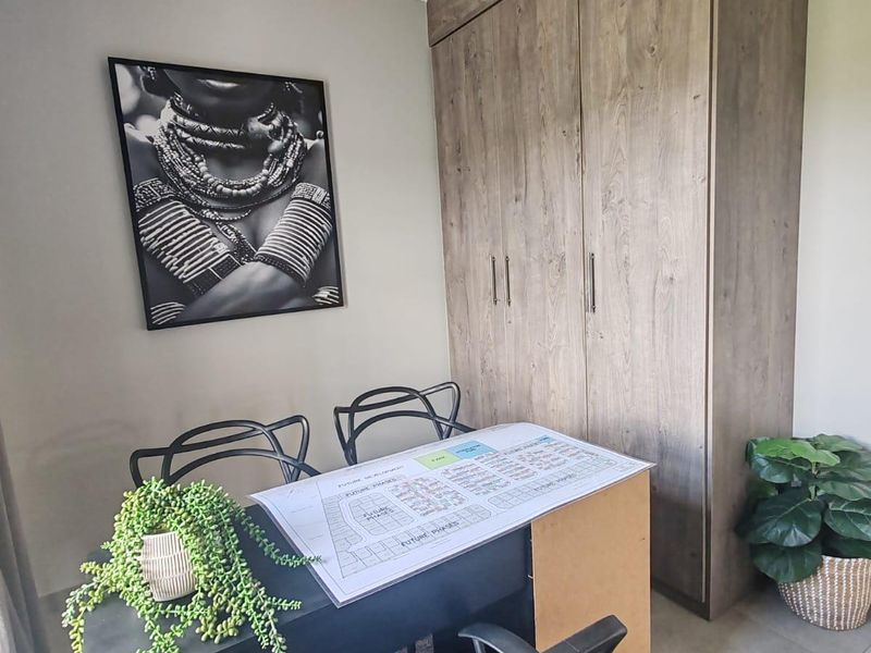 A well-maintained bedroom featuring neutral wall tones, tiled flooring, and floor-to-ceiling built-in wooden cupboards providing ample storage space.