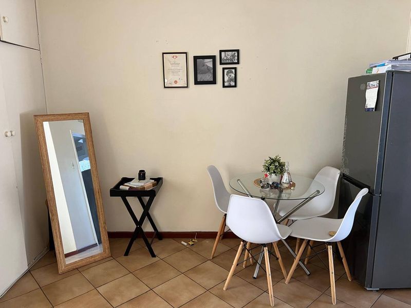 A functional dining area featuring tiled flooring and a built-in storage cupboard, providing a practical space for meals.