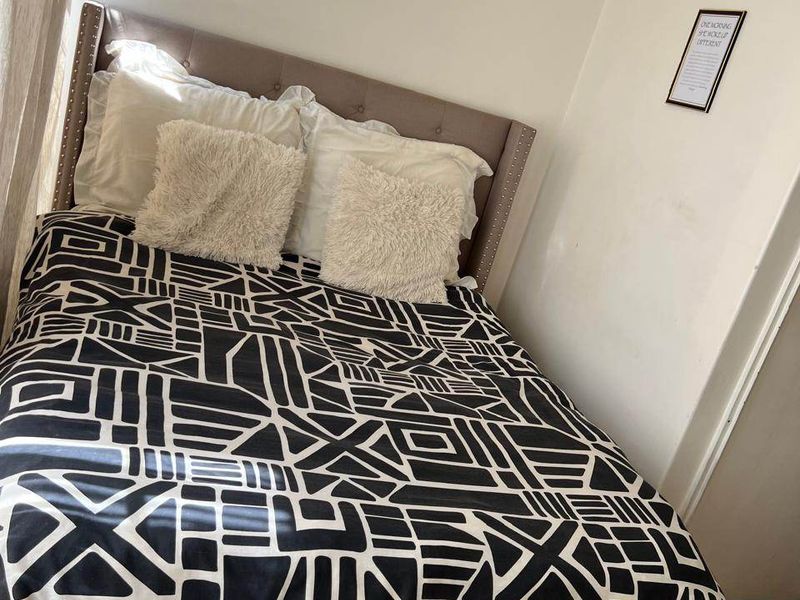 A bedroom featuring tiled flooring and neutral wall finishes, providing a functional space for rest.