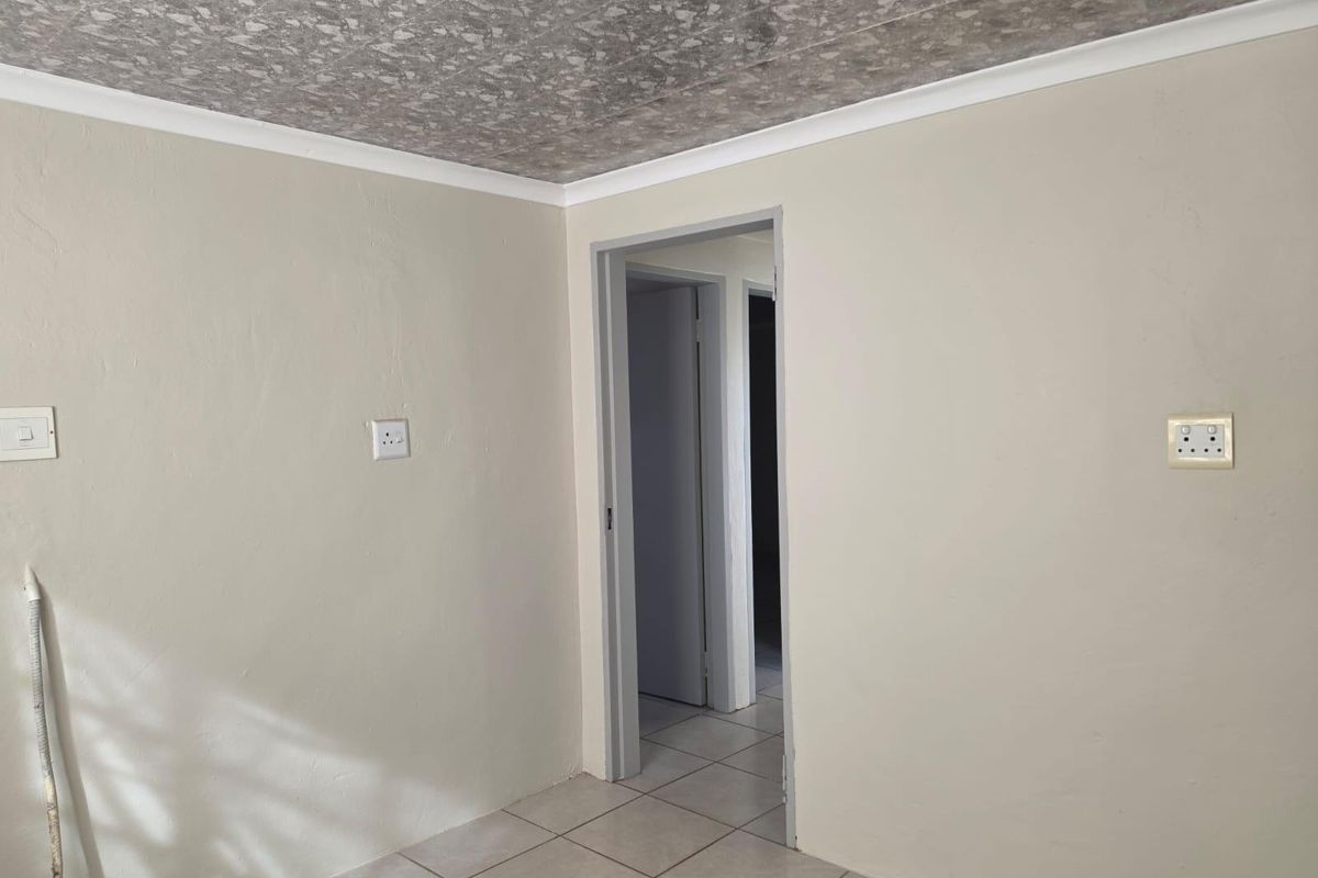 An empty bedroom featuring neutral wall paint, tiled flooring, and a textured ceiling finish, providing a blank canvas for interior design.