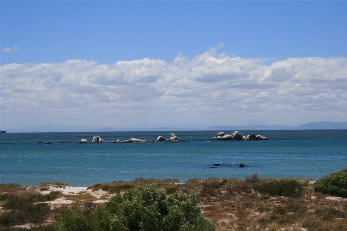 A scenic view of the ocean featuring natural rock formations and coastal vegetation, highlighting the property's prime waterfront location.