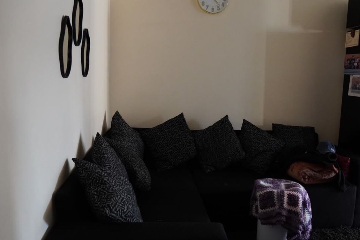 A corner view of a living room space featuring neutral wall finishes.