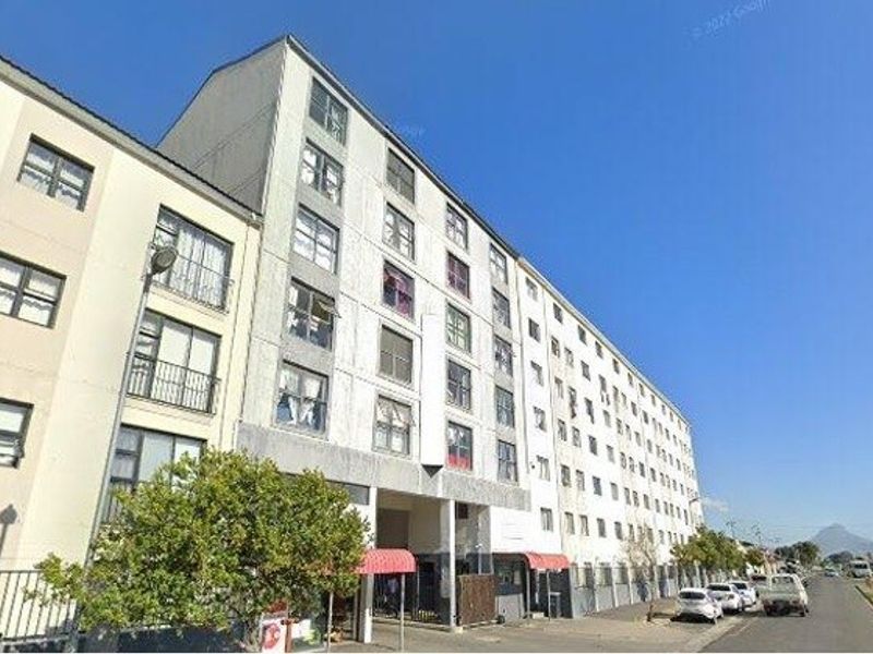 Exterior view of a multi-story apartment building featuring a street-level entrance and balcony access.