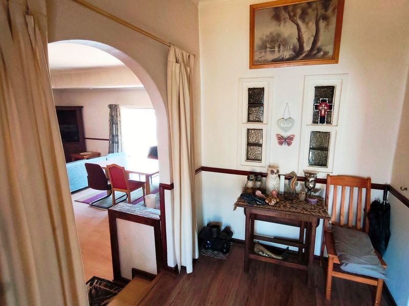 Entryway featuring an arched transition to the living area, decorative stained glass inserts, and wood-look laminate flooring.