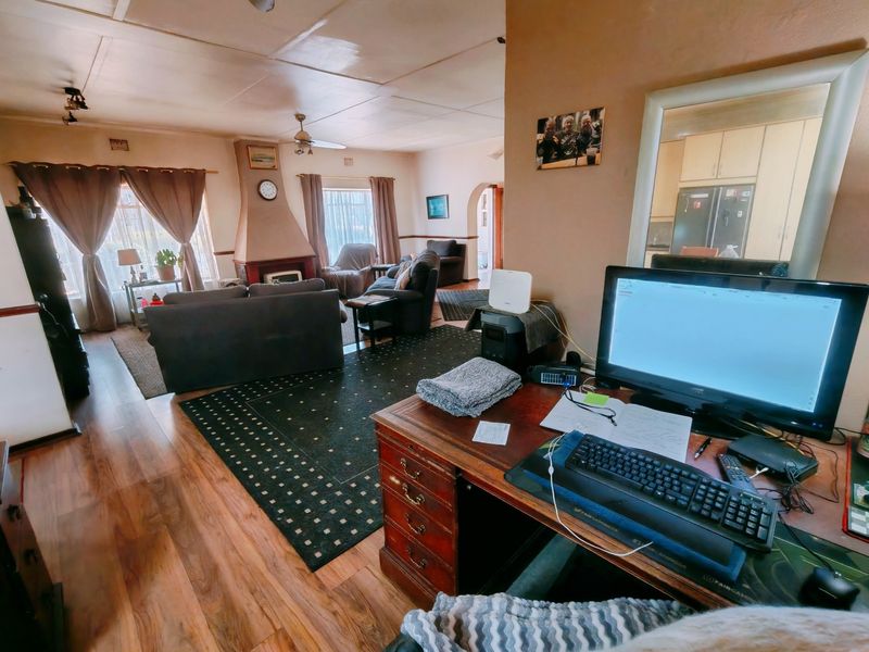 Open plan living area featuring a central fireplace, laminate flooring, and an archway leading to the kitchen area.