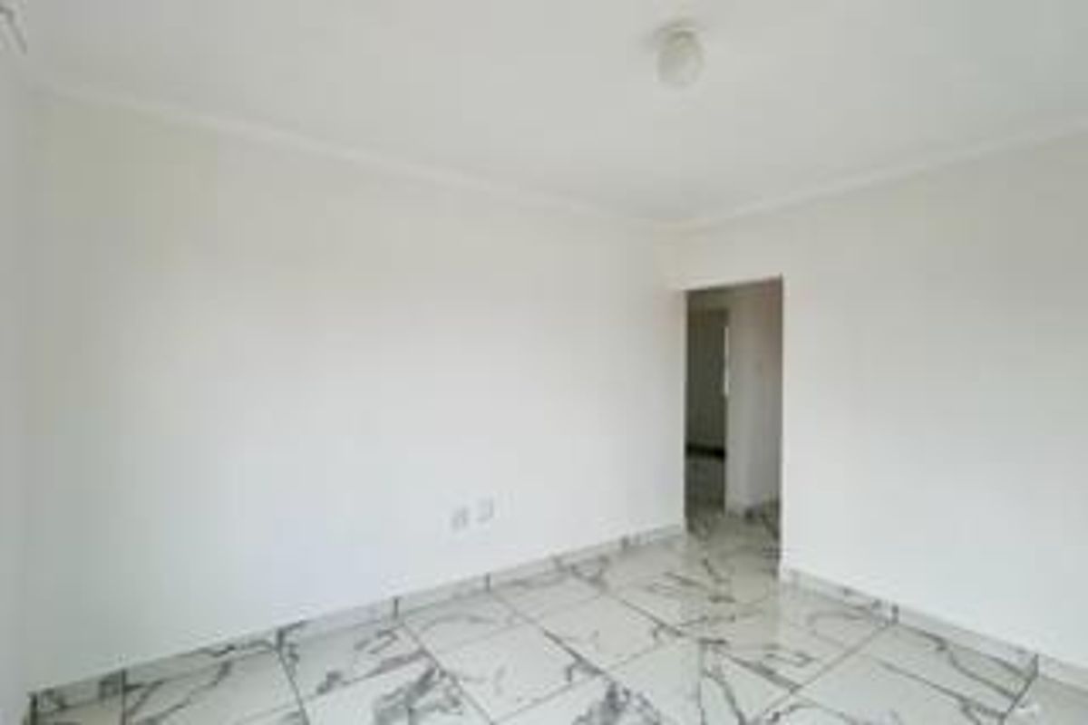 An empty living area featuring modern marble-look floor tiles, neutral white walls, and a simple ceiling light fixture.