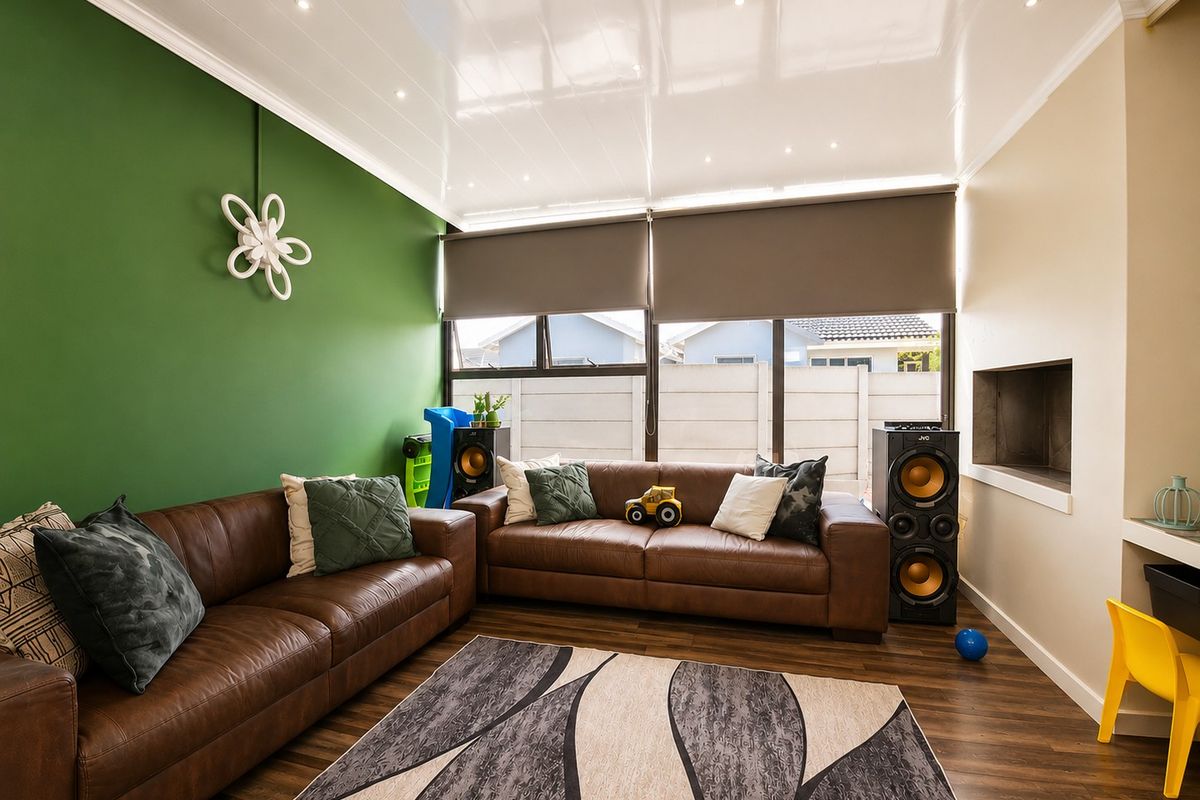 A comfortable living room featuring laminate flooring, recessed downlights, a built-in fireplace, and large windows with roller blinds.