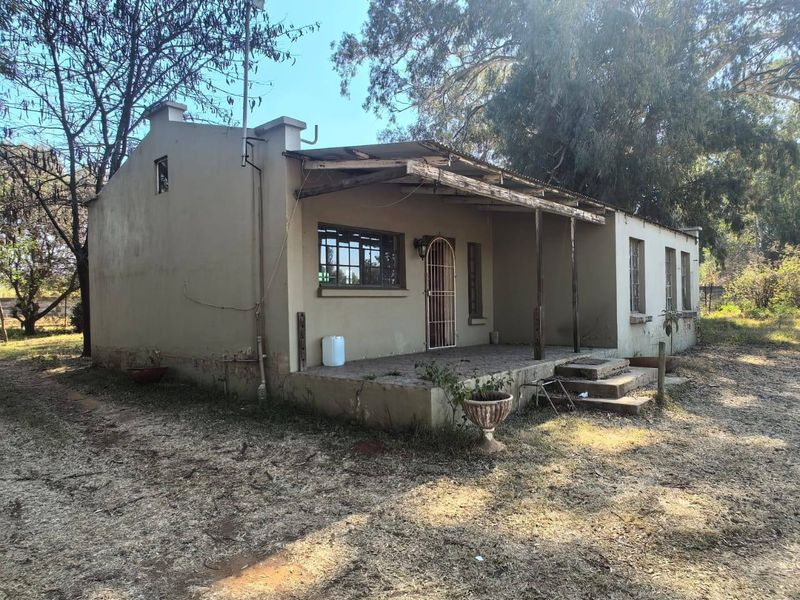 Front elevation of a single-story house featuring a covered patio area, requiring exterior maintenance and structural repairs to the timber roofing.