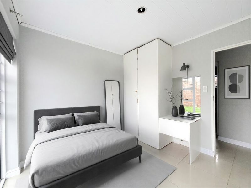 A well-maintained bedroom featuring neutral tones, tiled flooring, a built-in wardrobe with an integrated vanity area, and recessed ceiling lighting.