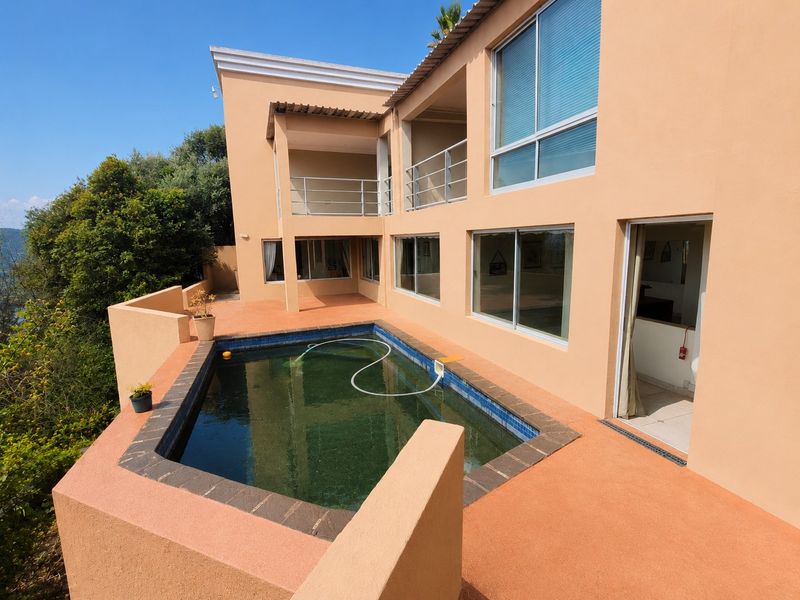 Rear exterior view featuring a swimming pool, tiled patio area, and multi-level balconies with access to the main house interior.