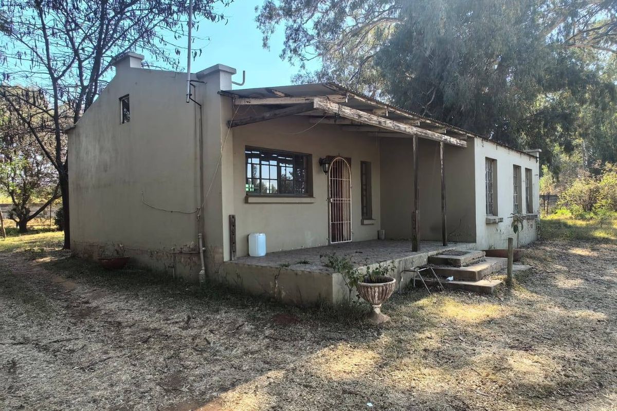 Rear view of the property featuring a covered patio area with a timber pergola structure and concrete steps leading to the entrance.