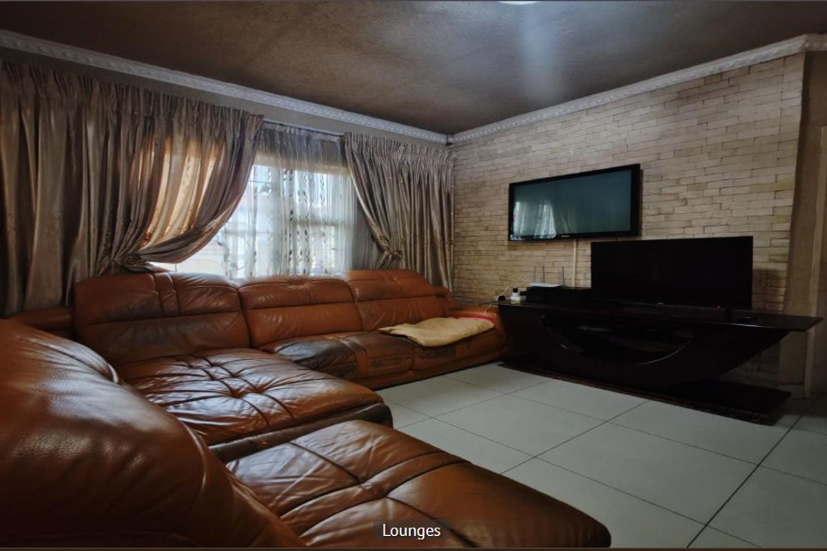 A living room featuring a stone veneer accent wall, tiled flooring, and decorative crown molding.