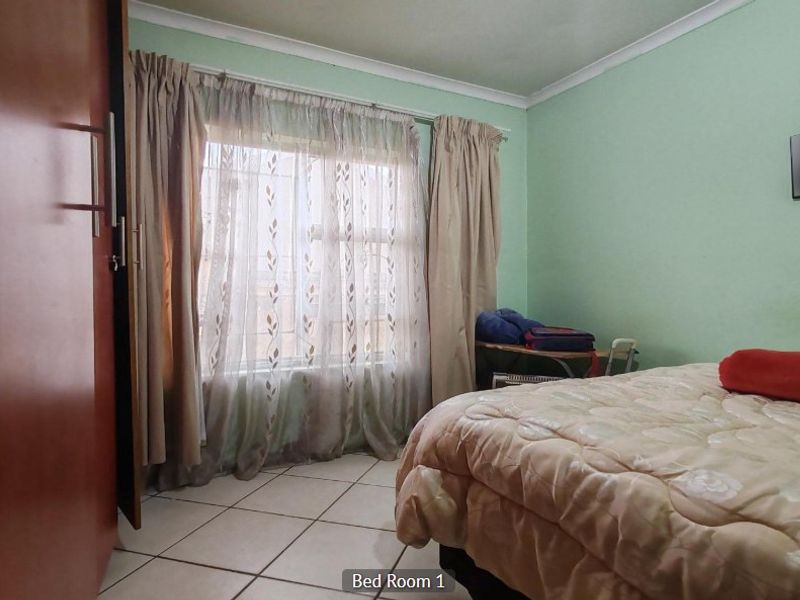 A bedroom featuring tiled flooring, a built-in wardrobe, and cove cornice detailing.