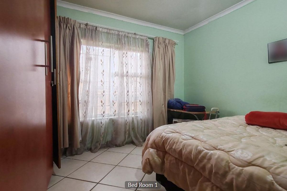 A bedroom featuring tiled flooring, a built-in wardrobe, and cove cornice detailing.