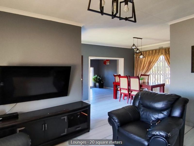 Open plan living and dining area featuring neutral grey walls, tiled flooring, and direct access to an adjacent room.
