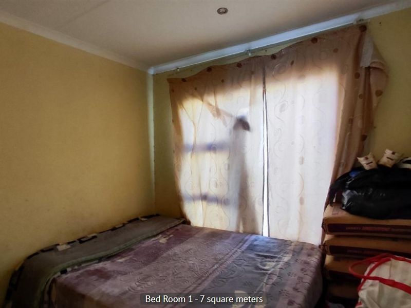 A compact bedroom featuring recessed downlights and coving, currently requiring cosmetic updates to the wall finishes.