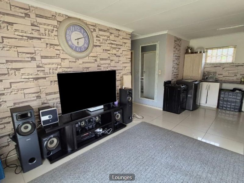 Open-plan living area featuring tiled flooring and an integrated kitchen space with cabinetry and countertops.