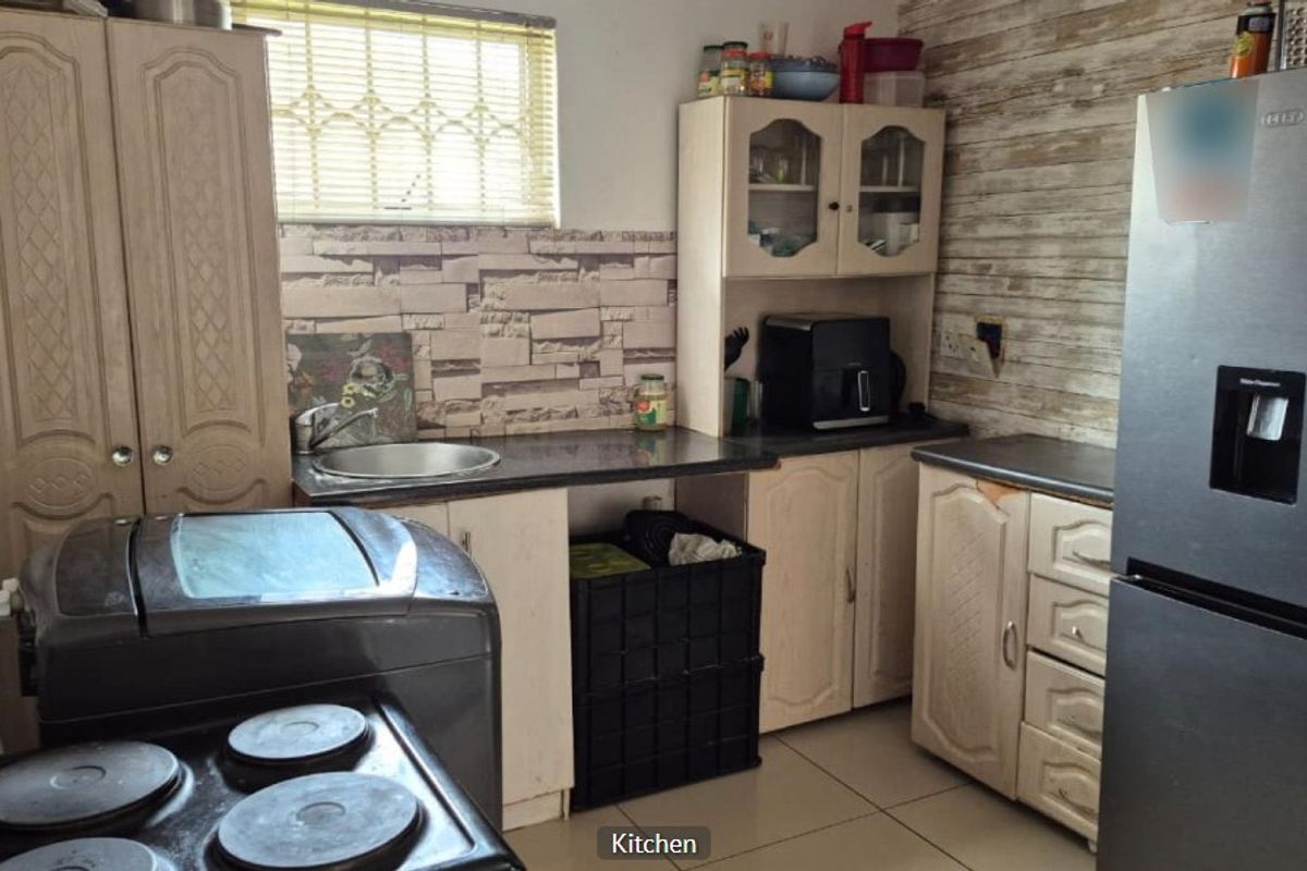 Compact kitchen featuring built-in cabinetry, laminate countertops, a stainless steel sink, and tiled backsplash, offering a functional layout with potential for cosmetic updates.