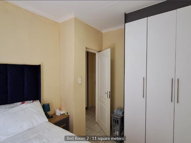 A bedroom featuring a built-in wardrobe and neutral wall finishes, providing a functional space with standard architectural elements.