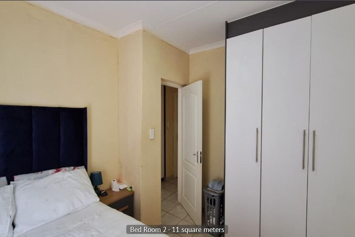 A bedroom featuring a built-in wardrobe and neutral wall finishes, providing a functional space with standard architectural elements.