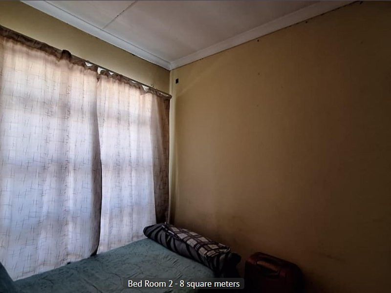 A compact bedroom measuring approximately 8 square meters, featuring a window with curtains and plain wall finishes.